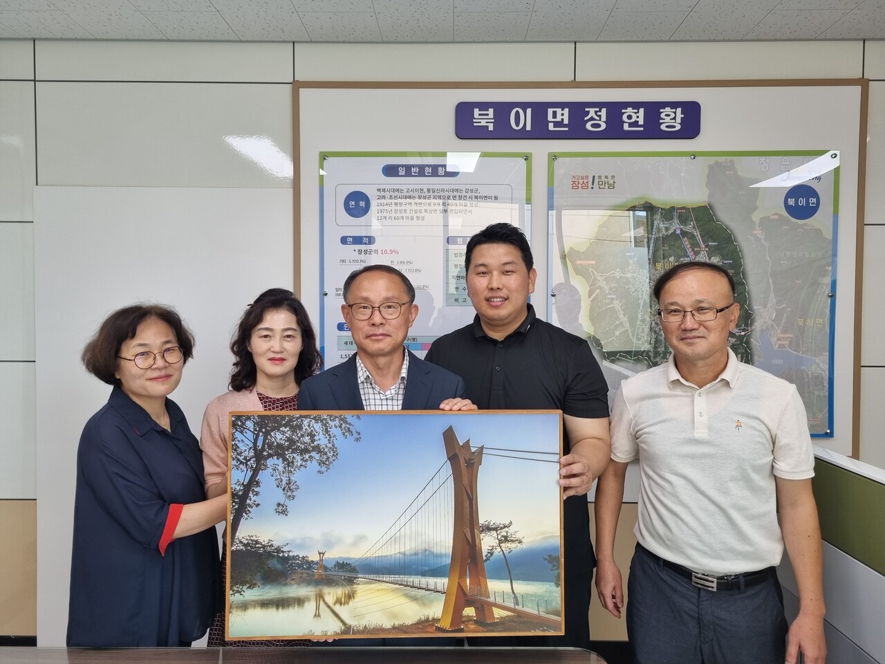 김우진 작가(사진 오른쪽에서 두번째)가 북이면행정복지센터 류현성 면장(사진 가운데)을 비롯한 직원들과 함께 기념 촬영을 하고 있다. 