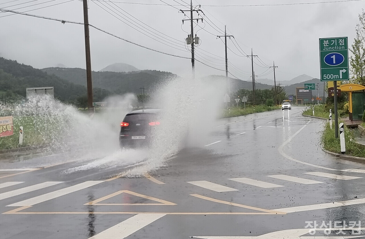 장성읍 백계리 고속도로 박스 앞 신흥로 하행선 쪽 도로에 빗물이 고여 지나는 차량이 물보라를 일으키며 위험하게 달리고 있다.